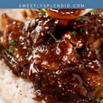 A bowl of white rice topped with glazed boneless beef ribs, sprinkled with sesame seeds and chopped herbs. A blue banner above reads Boneless Beef Ribs sweetlysplendid.com, showcasing this delicious boneless beef ribs recipe.