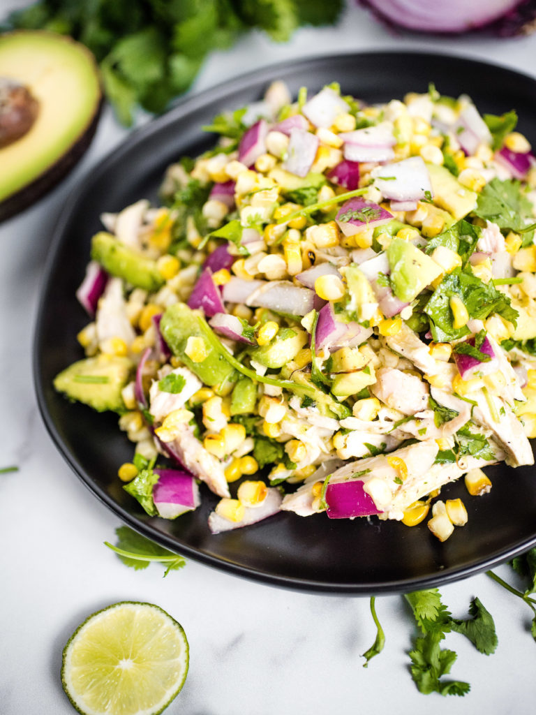 avocado chicken chopped salad on a black plate