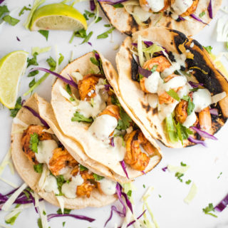 chili lime shrimp tacos in charred white corn tortillas with cabbage slaw and avocado cilantro dressing