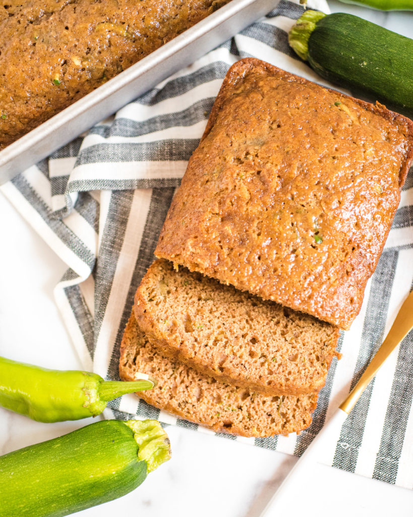 green chile zucchini bread sliced on a striped kitchen towel