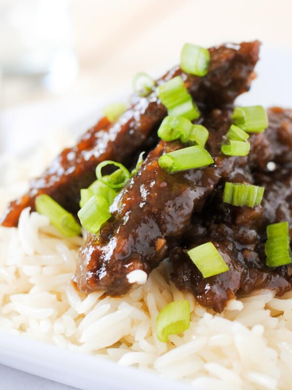beef teriyaki on white rice on a white plate