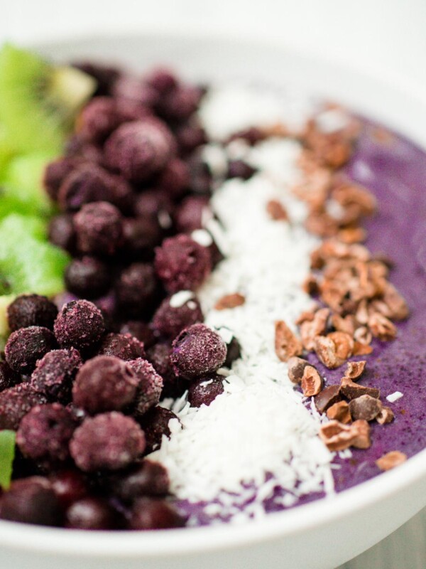 blueberry banana smoothie bowl in a white bowl with toppings