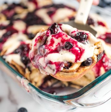 Blueberry Cinnamon Rolls being scooped from pyrex dish