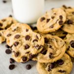 a stack of chocolate chip cookies in front of milk