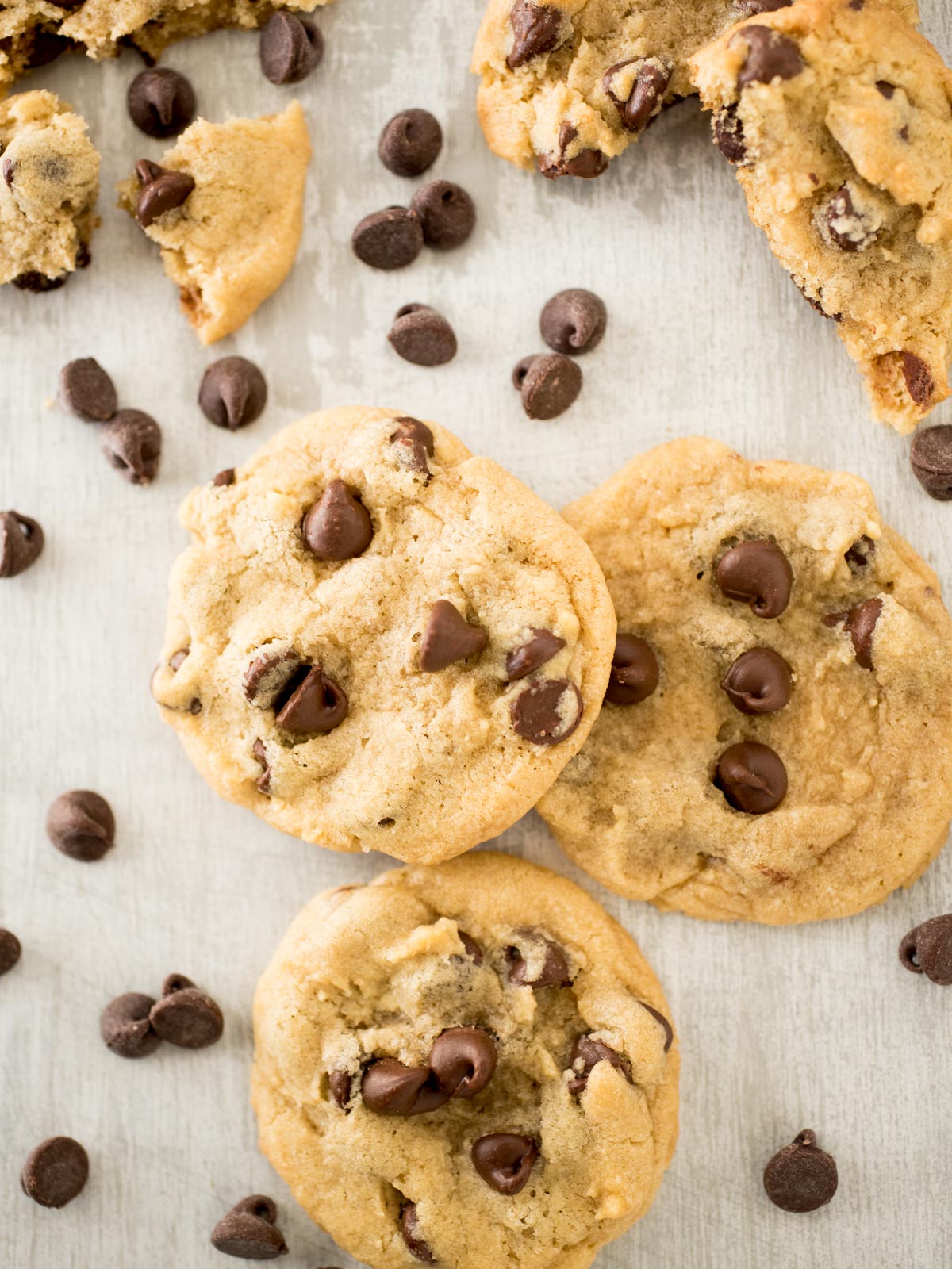 stack of chocolate chip cookies surrounded by chocolate chips