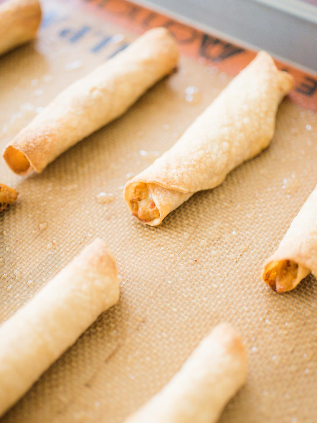 chicken taquitos on a silicone lined baking sheet