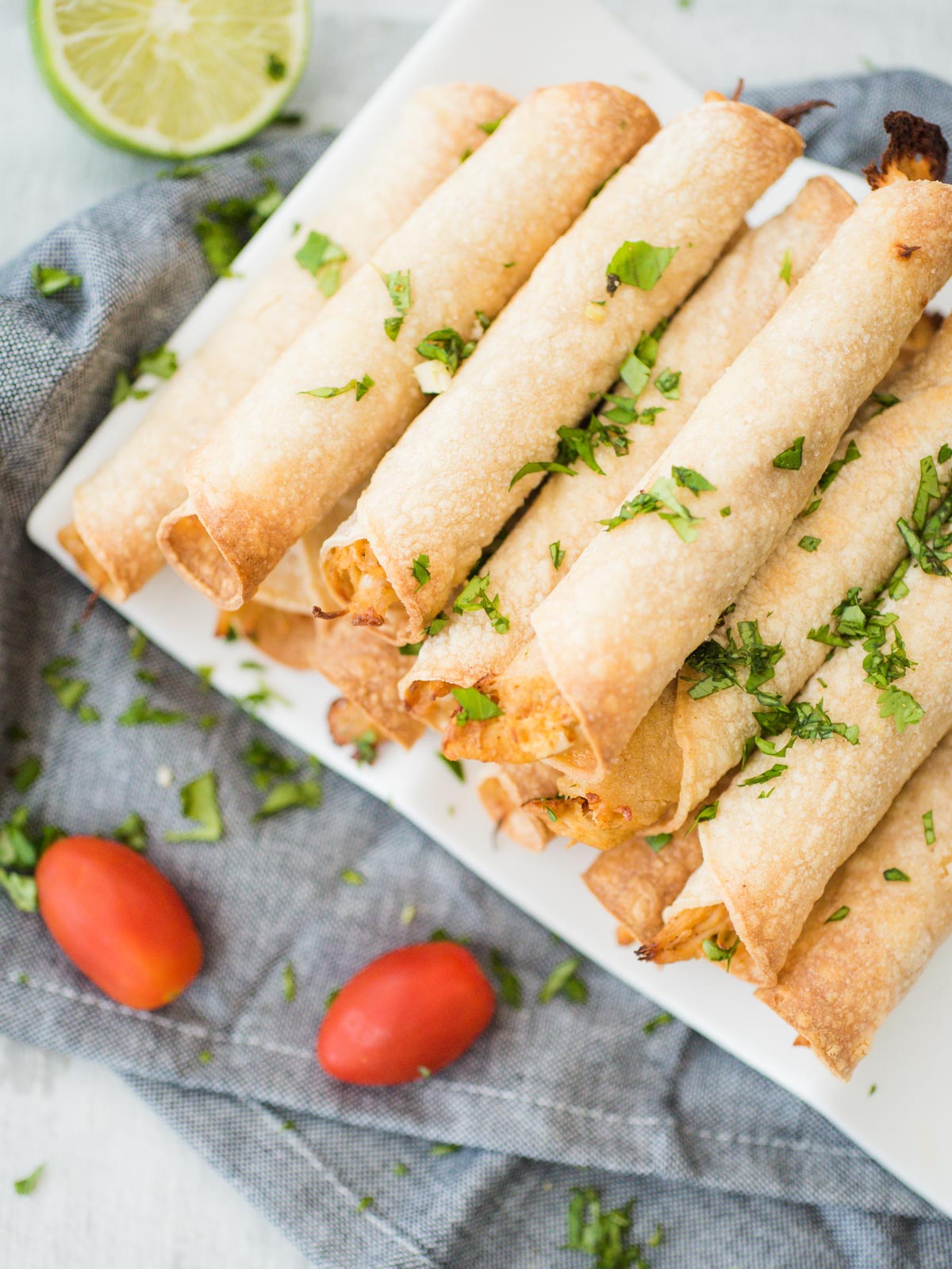 stack of chicken taquitos on a white plate