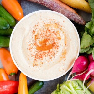 hummus sprinkled with paprika in white bowl