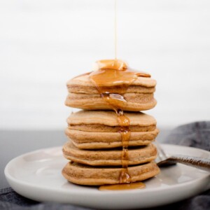 gingerbreak panckes topped with butter being drizzled with syrup