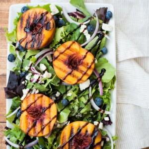 grilled peach salad on a white plate