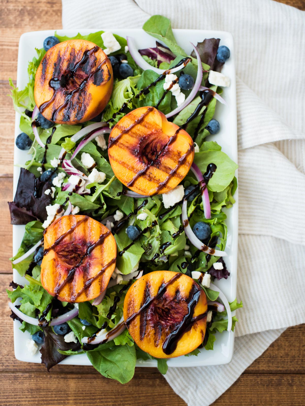 grilled peach salad on a white plate