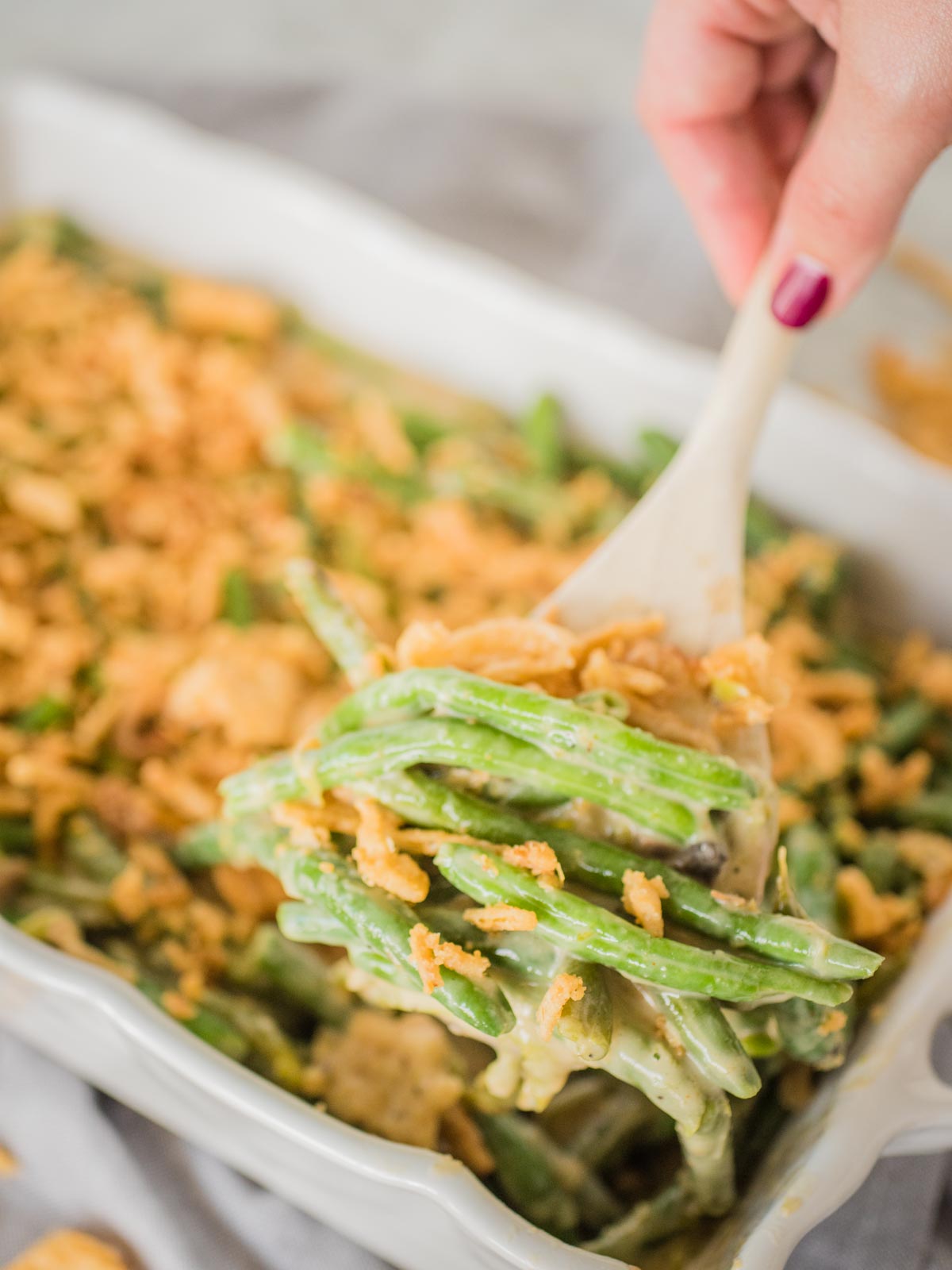 green bean casserole being scooped out of casserole dish