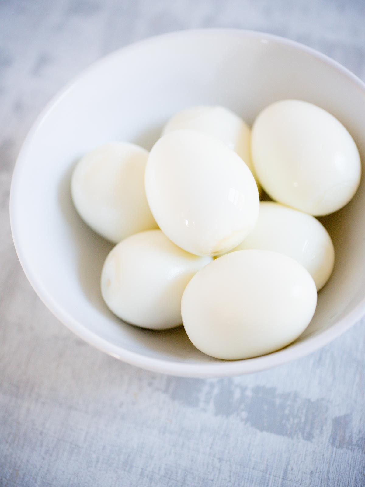 peeled hard boiled eggs in white bowl
