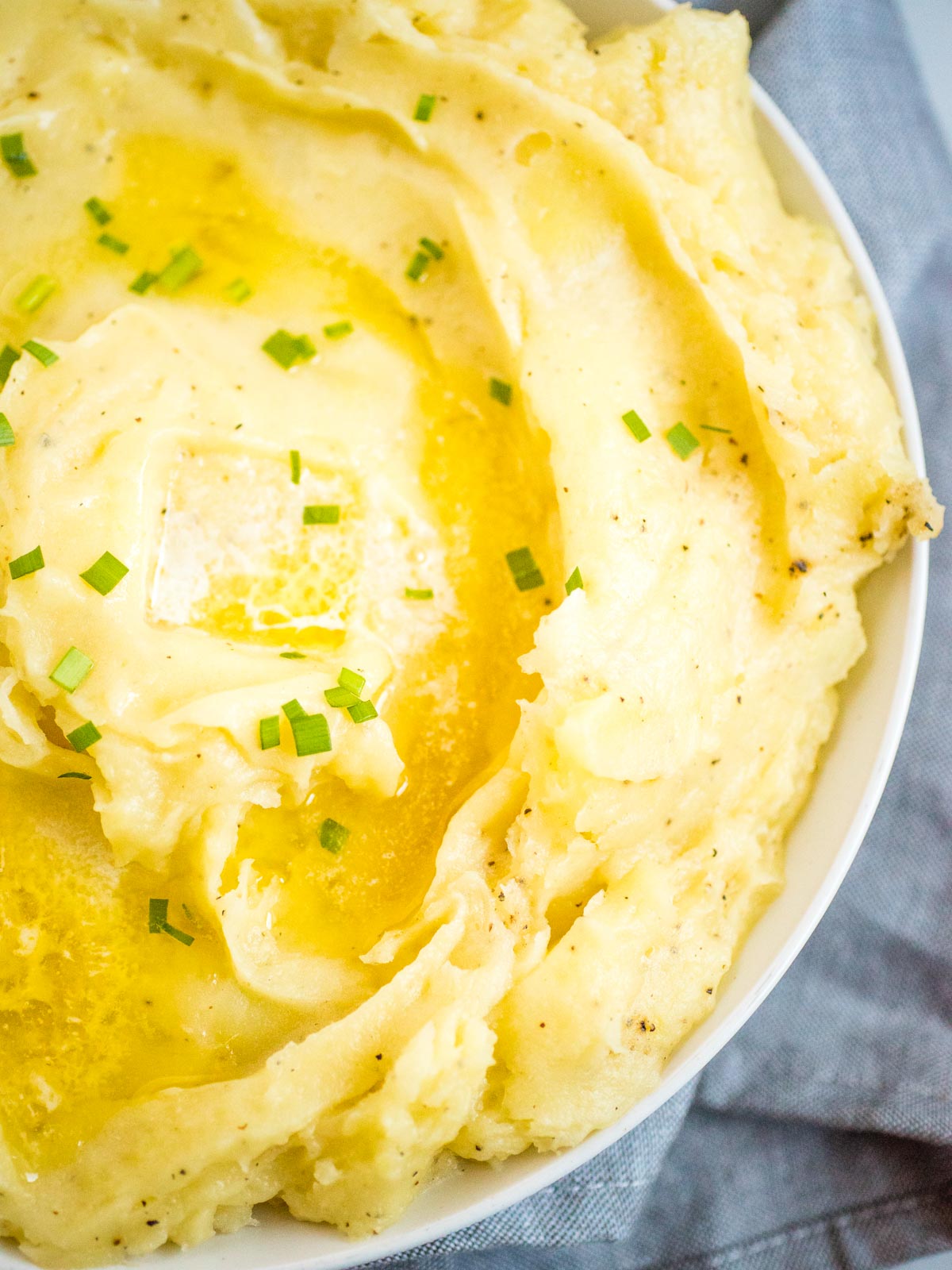 mashed potatoes with melted butter in a white dish