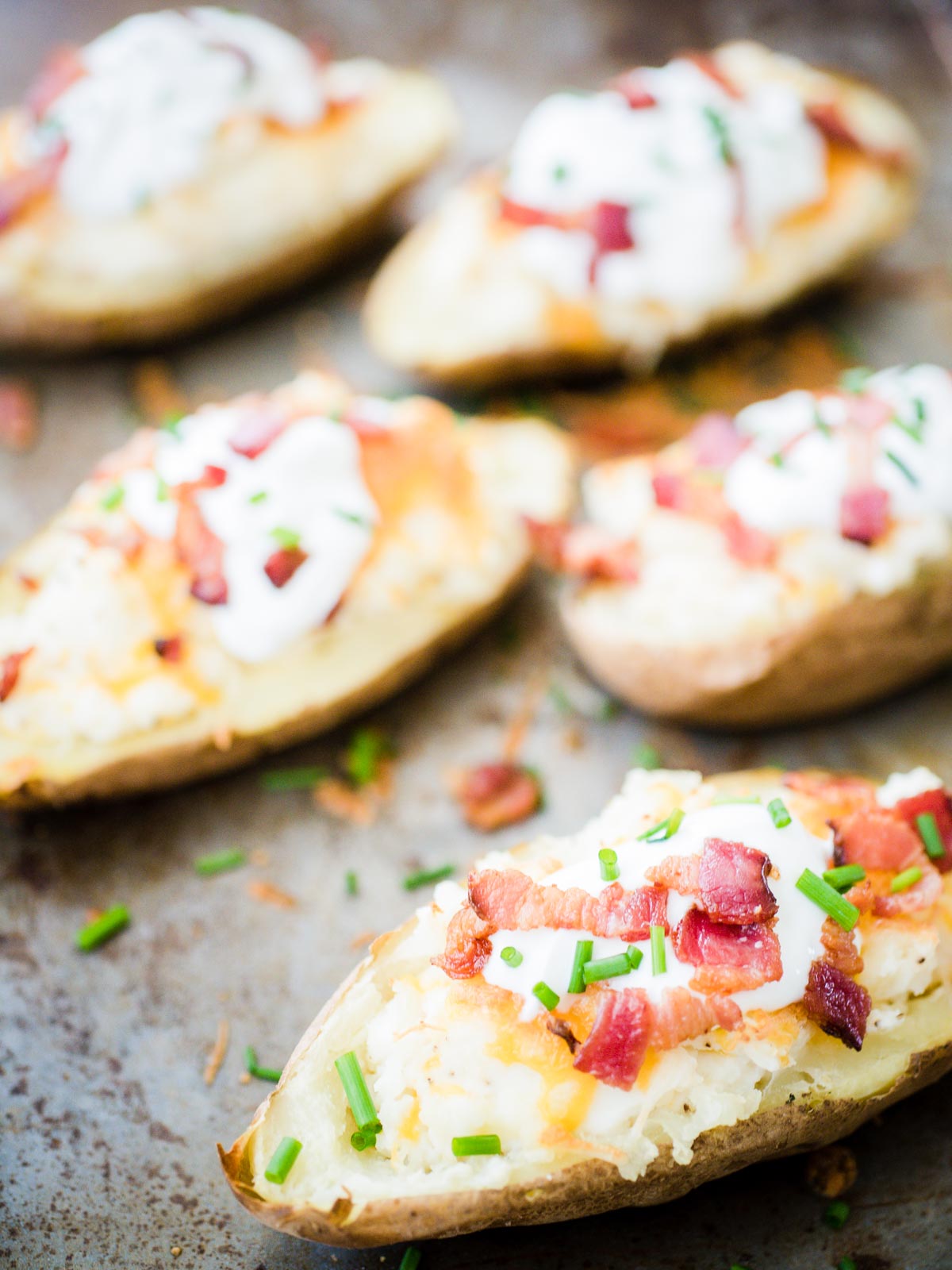 loaded twice baked potatoes on a baking sheet