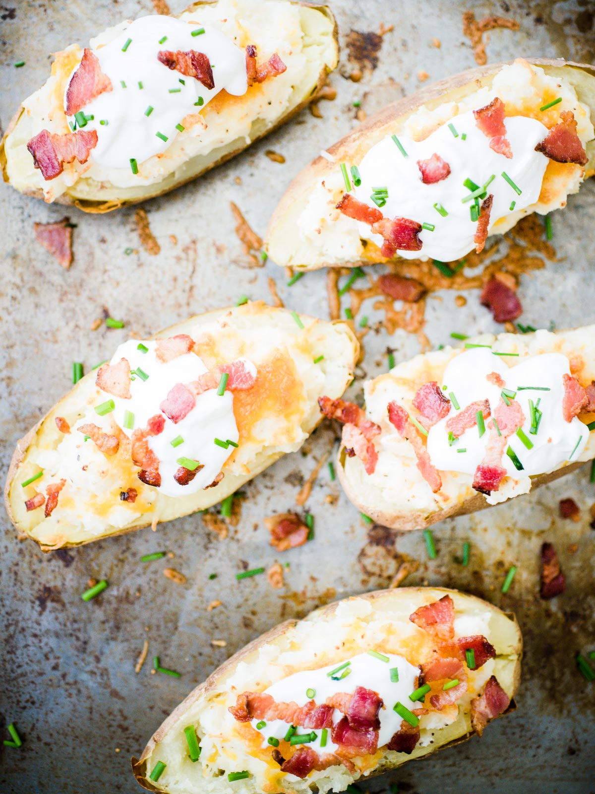 loaded twice baked potatoes on a baking sheet