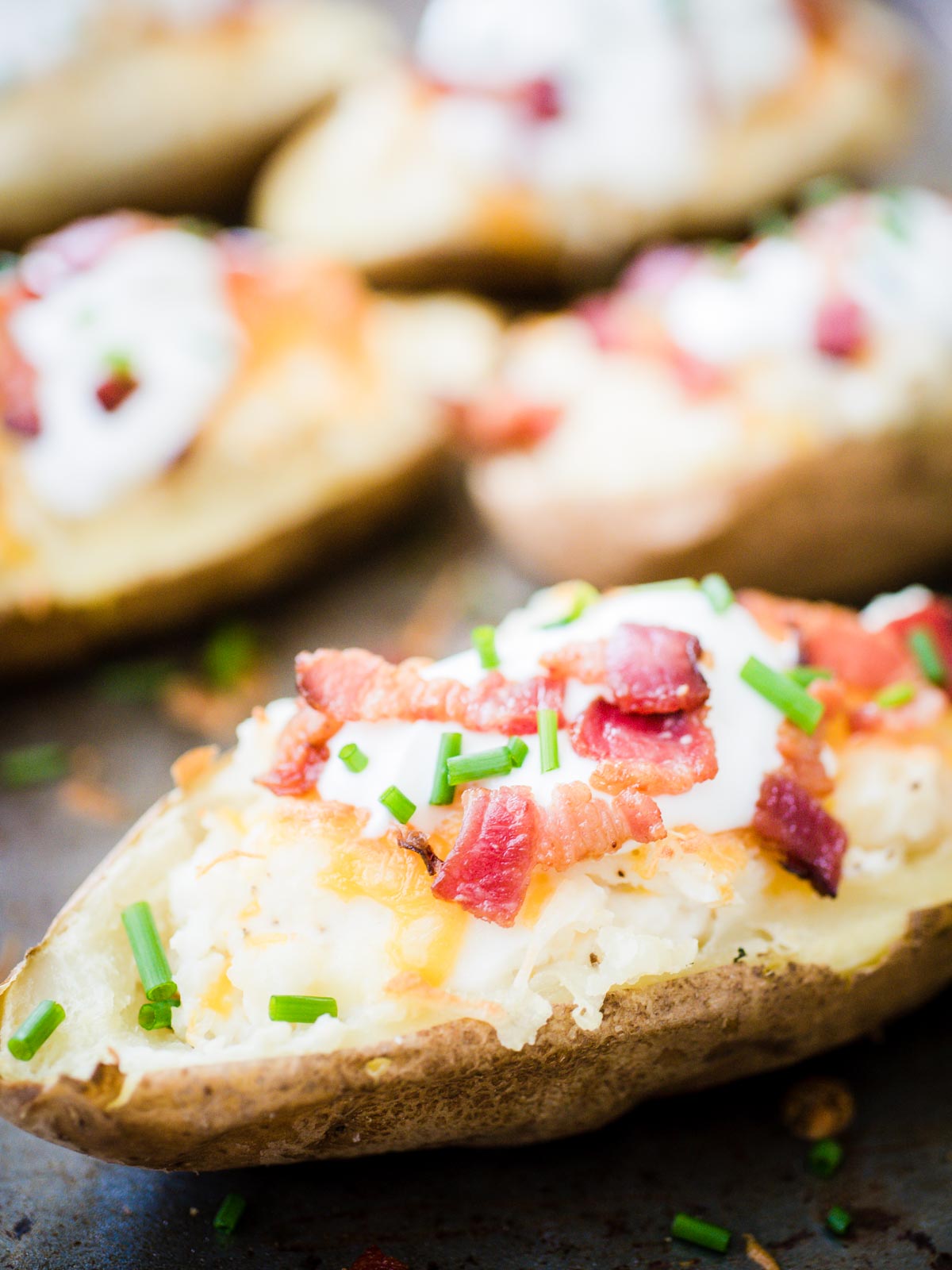 loaded twice baked potatoes on a baking sheet