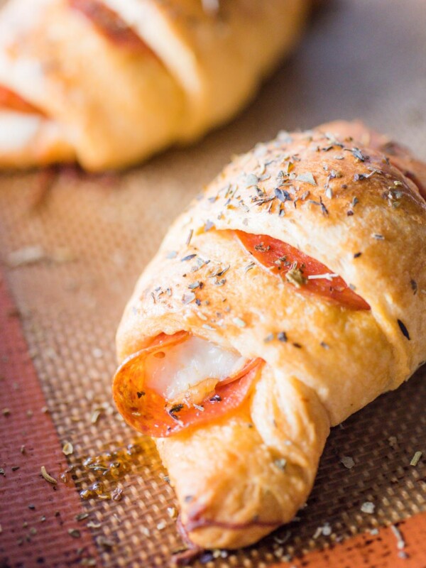 up close shot of pepperoni roll sitting on silpat lined baking sheet