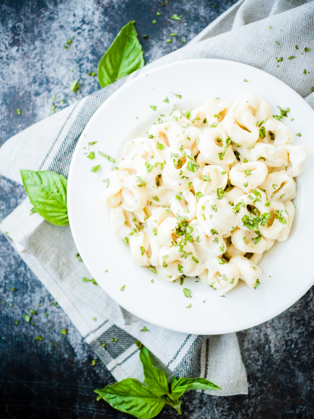 pasta covered in sauce and basil in a bowl