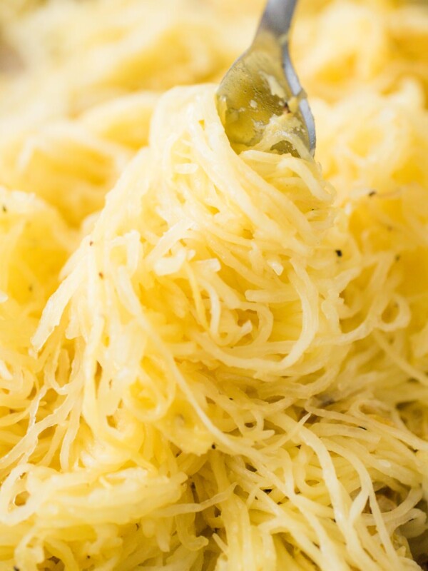 a pile of roasted spaghetti squash being twirled with a fork