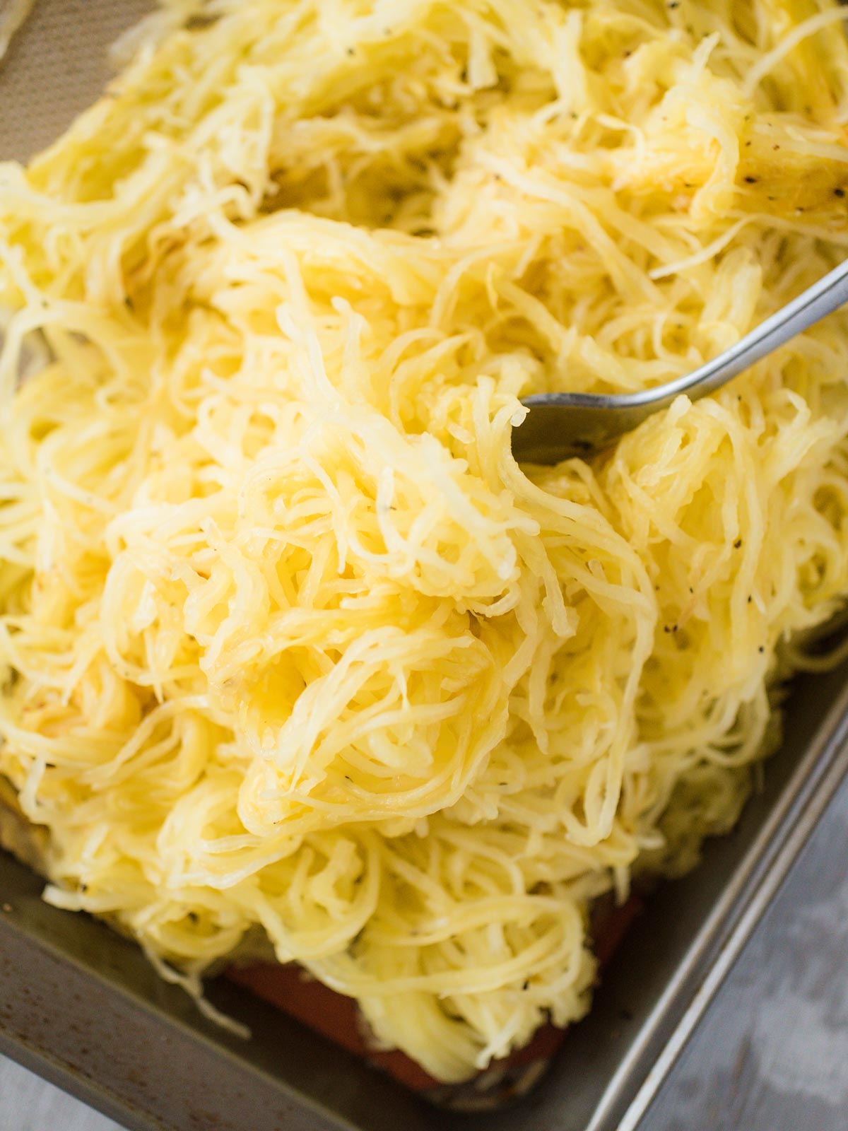 pile of roasted spaghetti squash with a fork laying in it