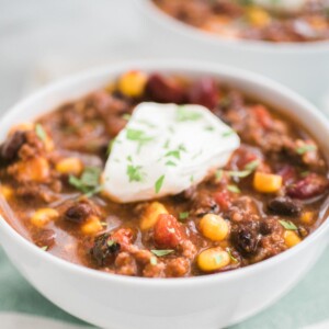 taco soup in a white bowl topped with sour cream
