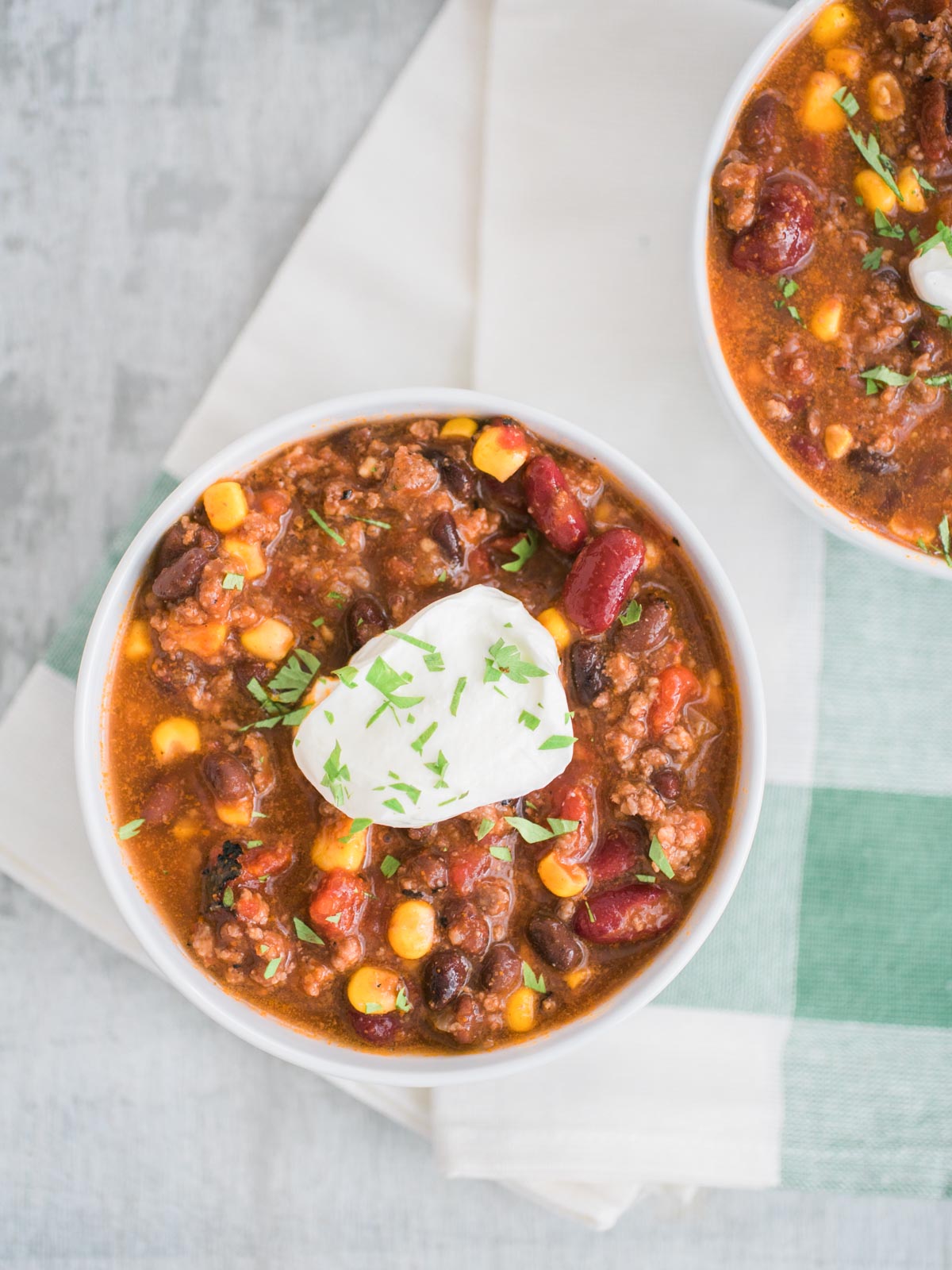 slow cooker taco soup in a white bowl topped with sour cream