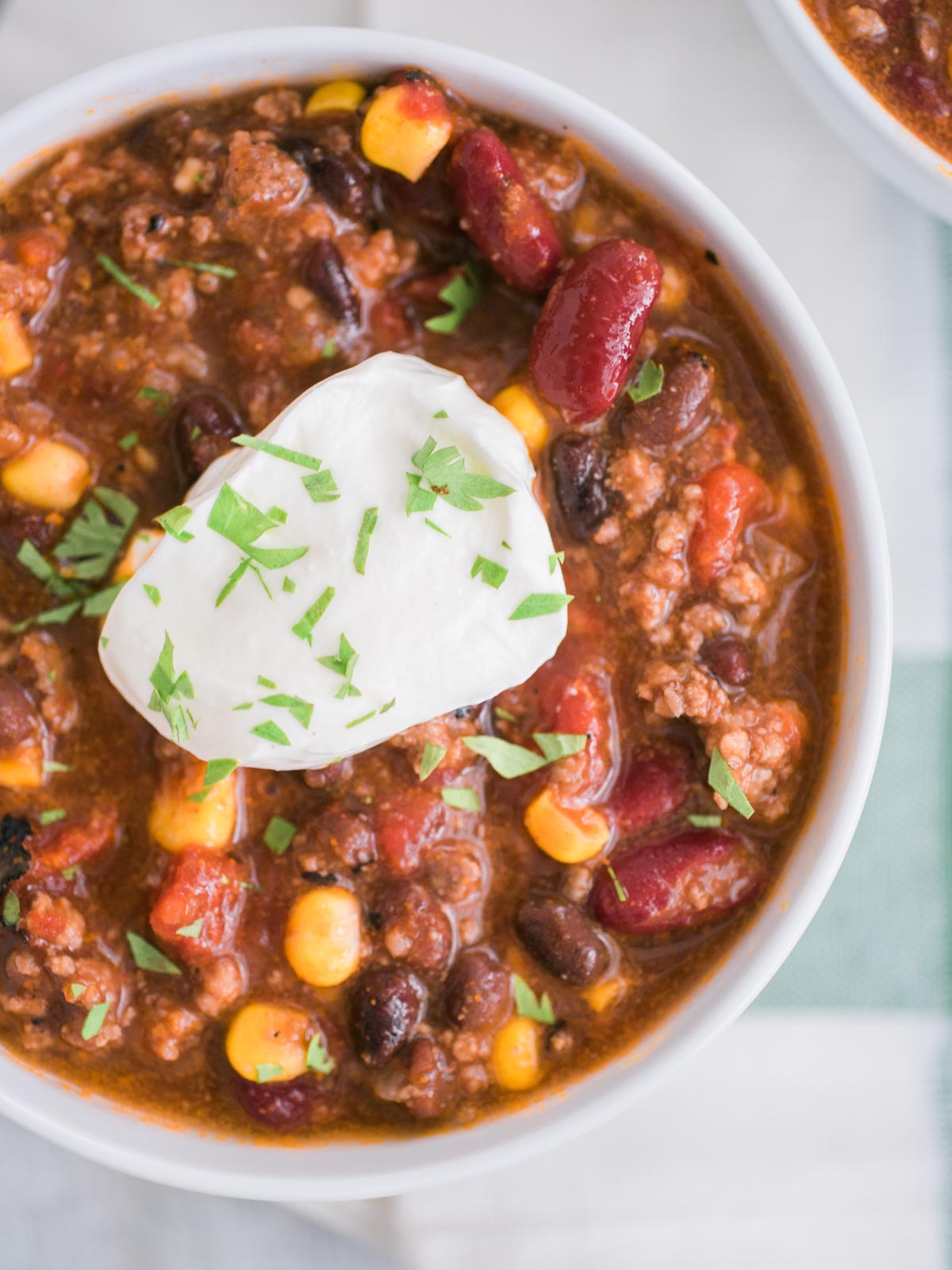 slow cooker taco soup in a white bowl topped with sour cream