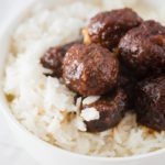 meatballs over rice in a white bowl