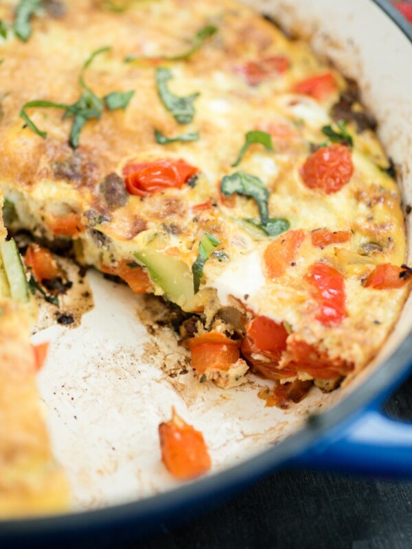 frittata in a cast iron enamel pan with slice removed