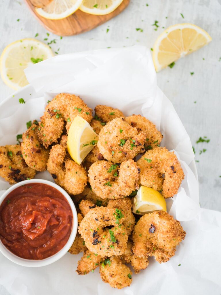 air fried shrimp in a bowl with dipping sauce topped with lemon