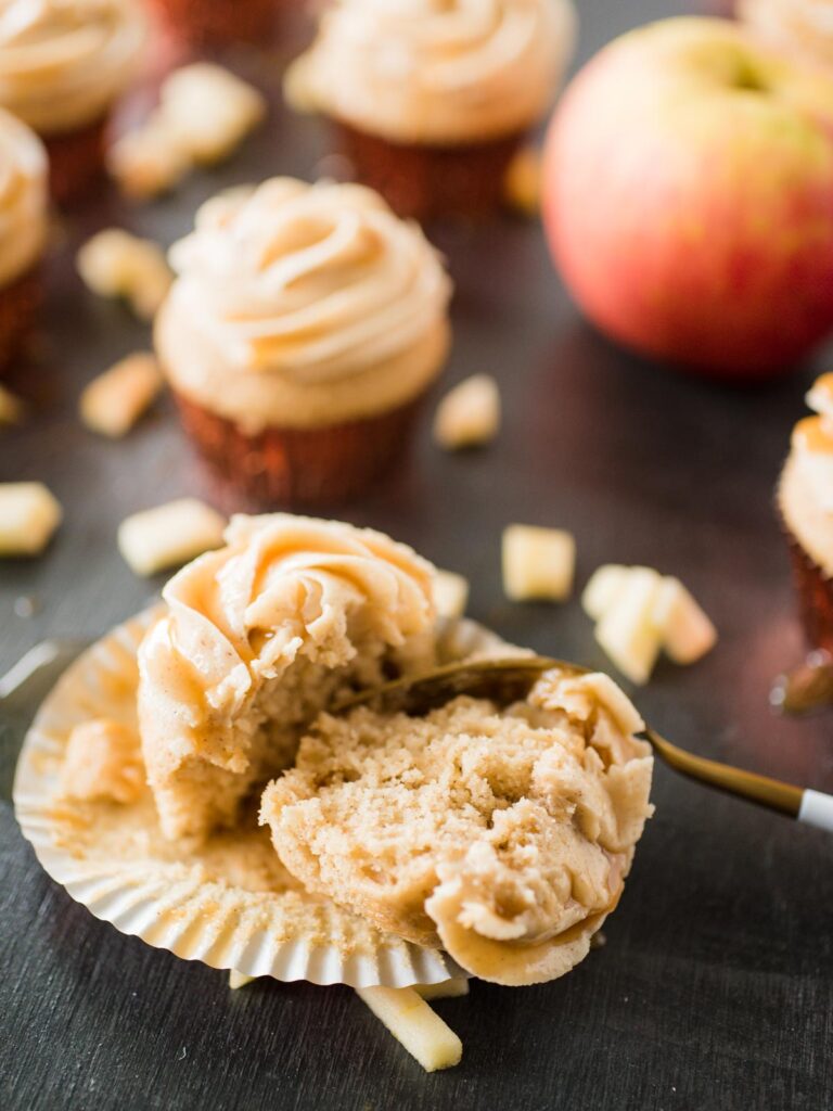 apple cider cupcake split with a gold and white fork laying in liner