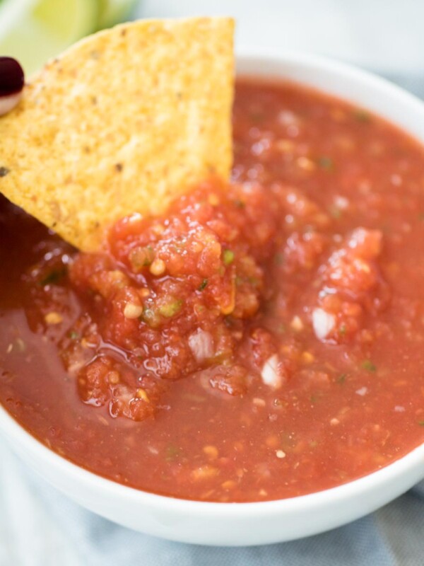 salsa in a bowl being dipped with a chip