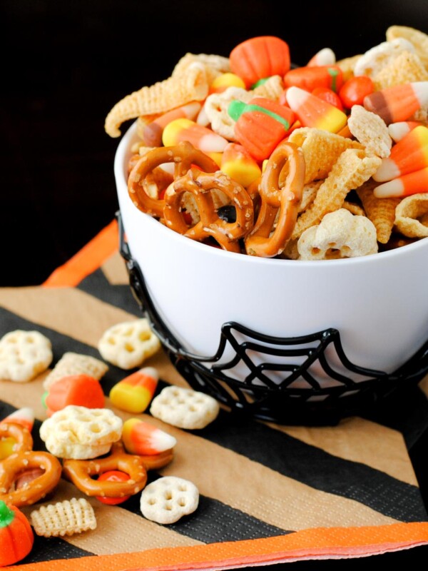 spooky snack mix in a spider bowl with a striped Halloween napkin