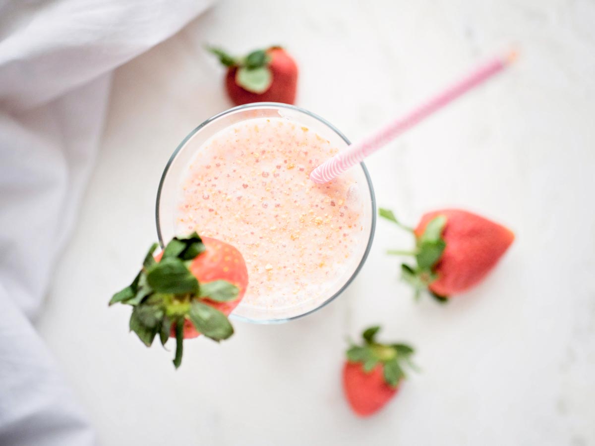 strawberry cheesecake smoothie topped with graham cracker crumbs and garnished with a strawberry