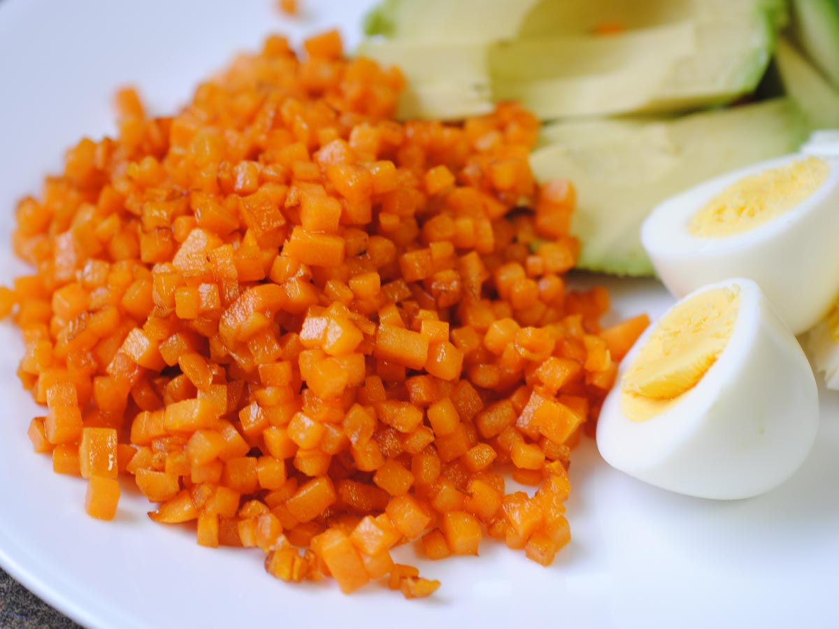 sweet potato hashbrowns on a plate with boiled eggs and avocado