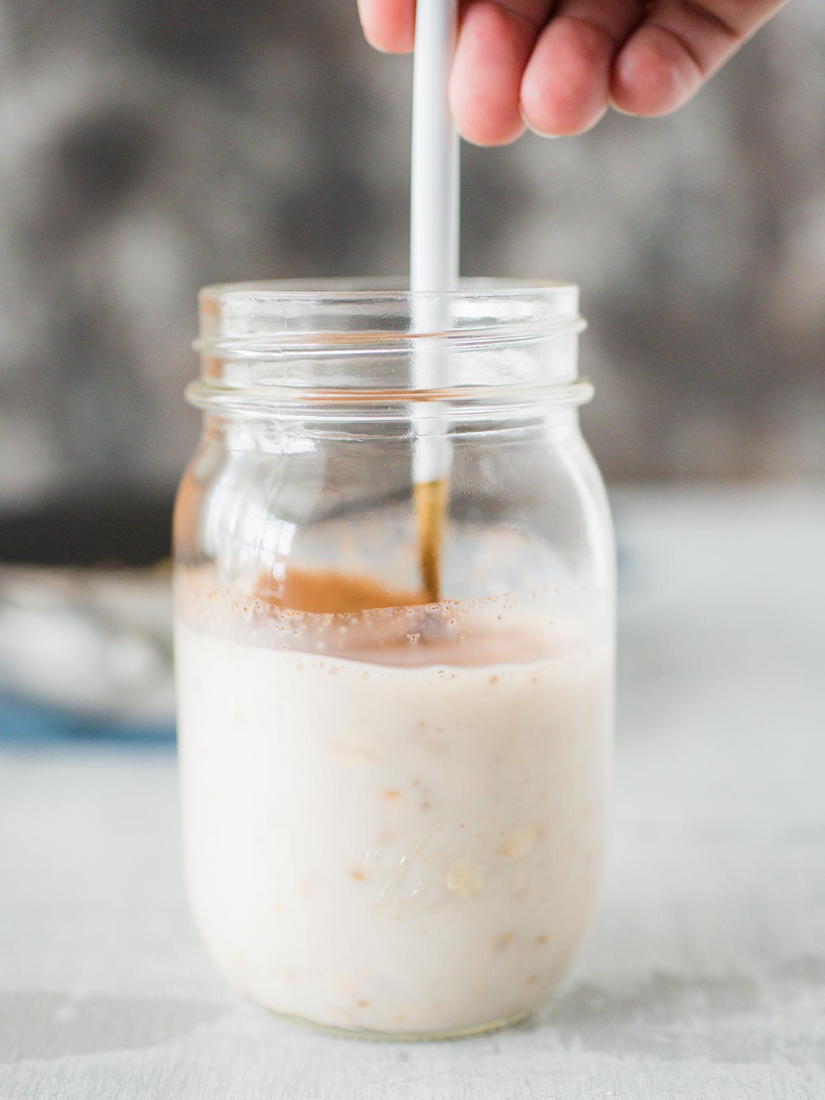 spoon stirring the apple pie overnight oats mix