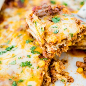 tex mex lasagna being scooped from casserole dish