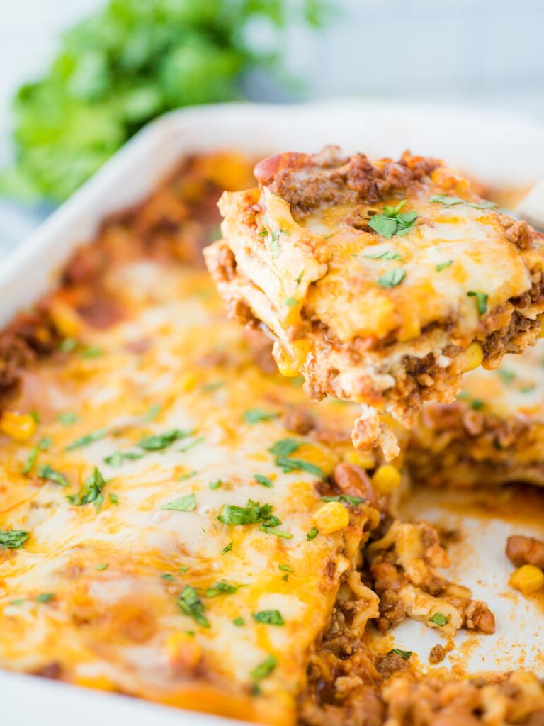 tex mex lasagna being scooped from casserole dish