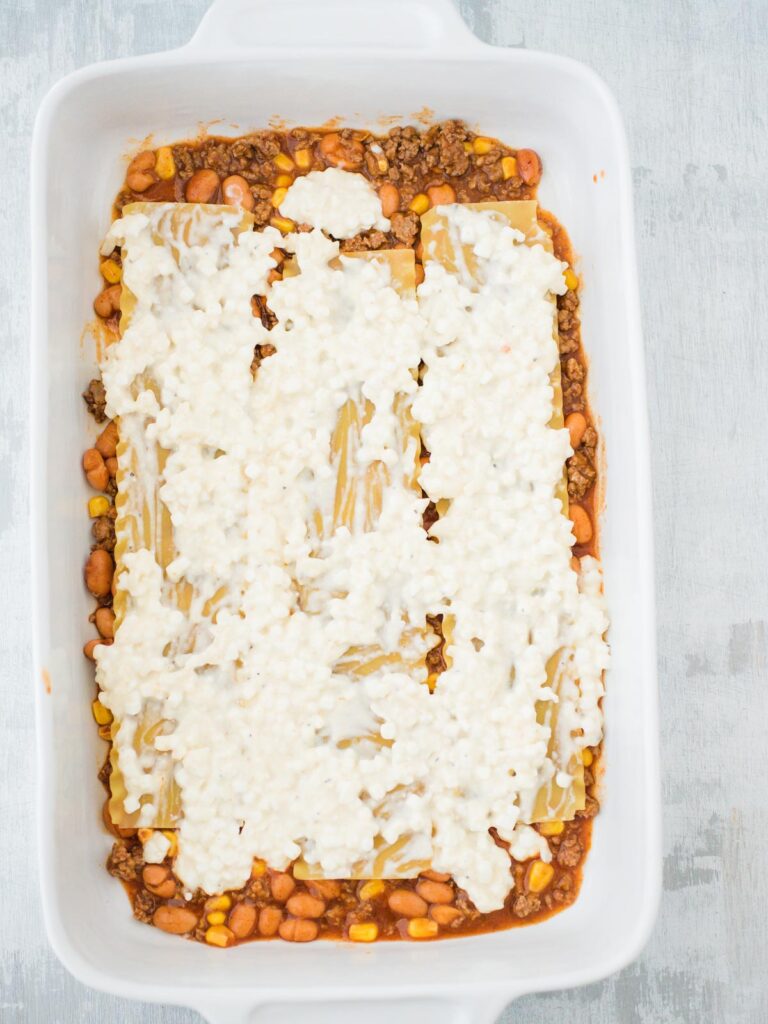 cheese mix layer of tex mex lasagna in a casserole dish
