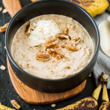banana overnight oats in bowl topped with whip cream and pecans