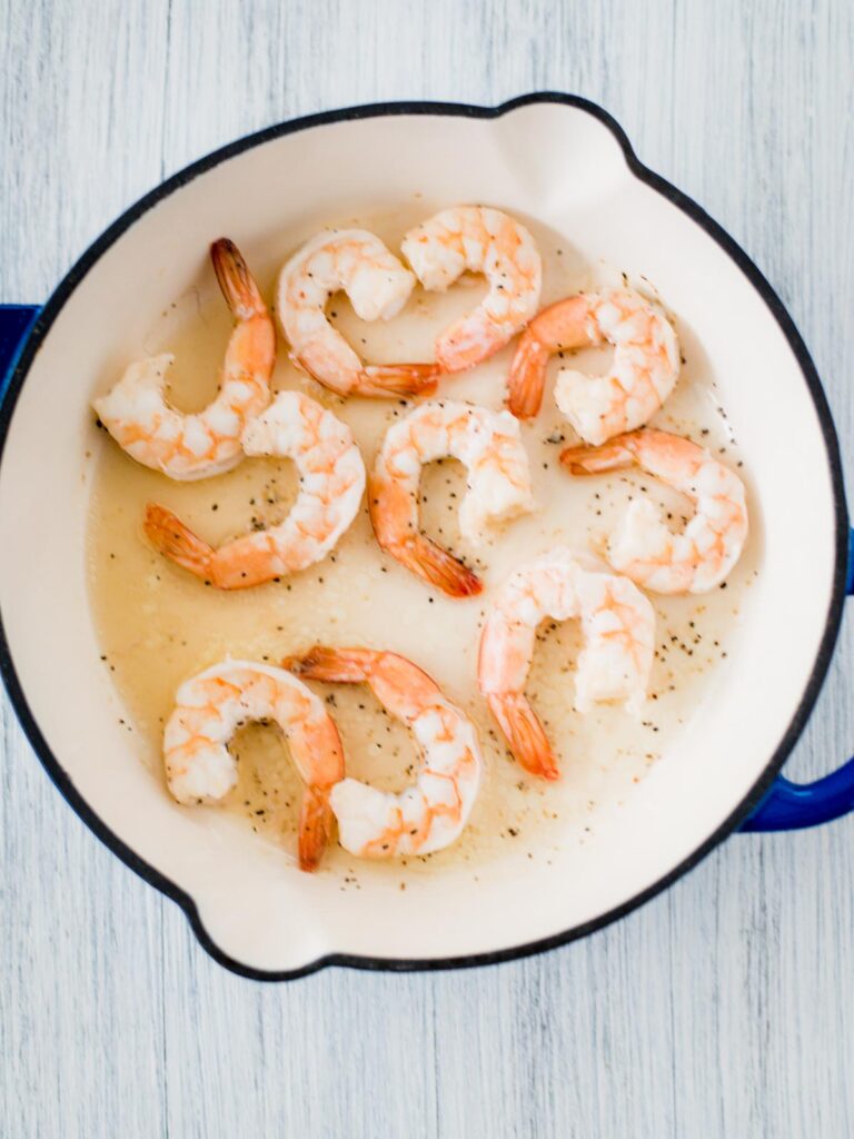 cooked shrimp in skillet with salt and pepper