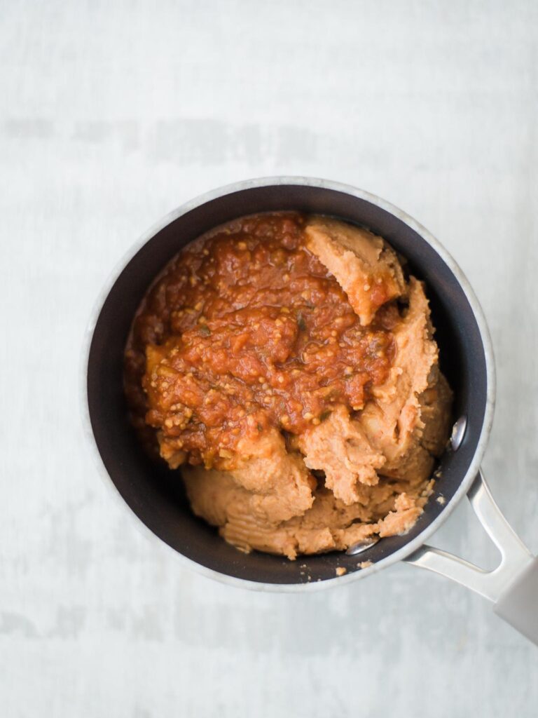 refried beans with salsa in sauce pan