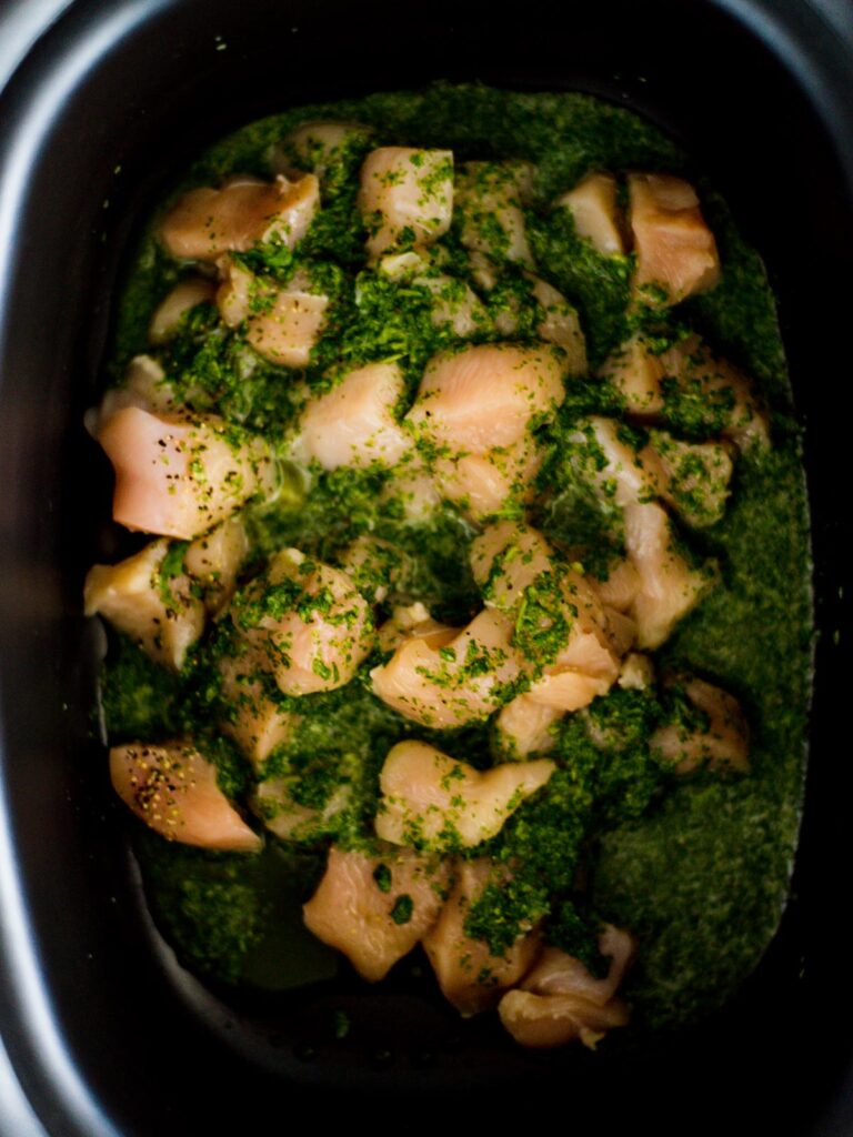 chicken with cilantro lime mix on top in slow cooker