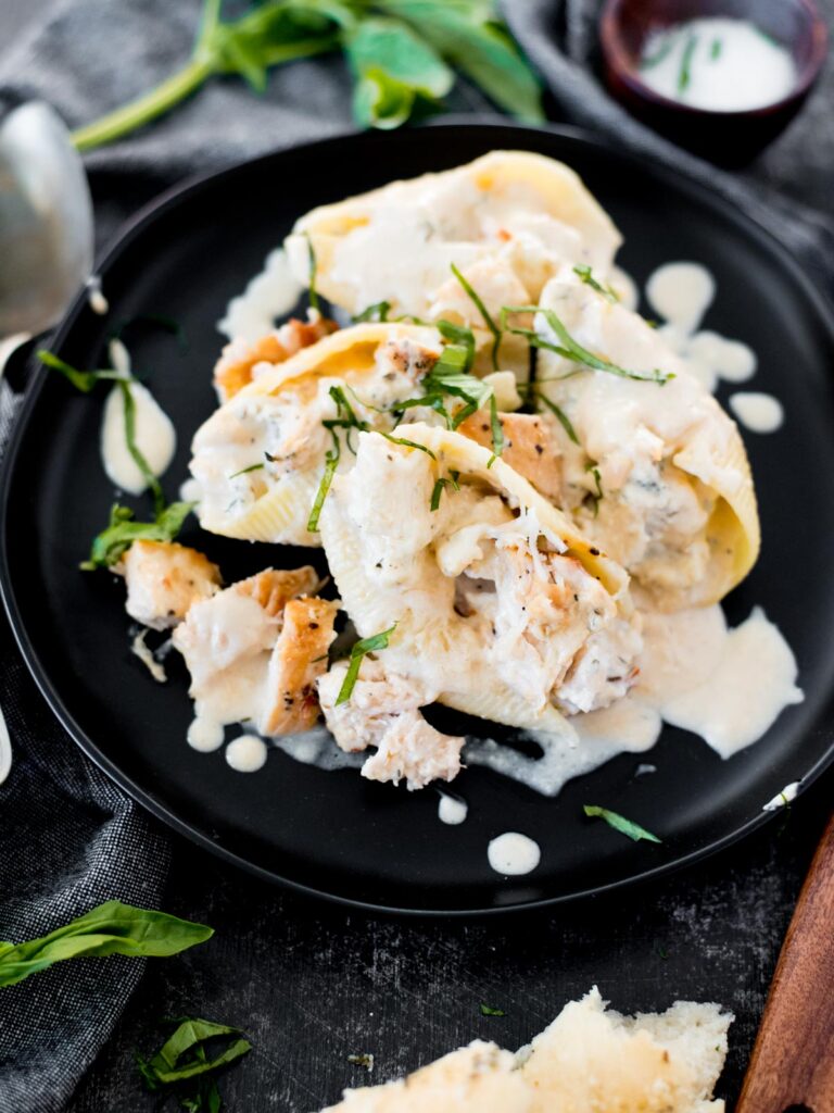 creamy chicken and ricotta stuffed shells topped with basil