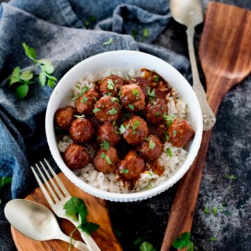 crockpot sweet and spicy meatballs on rice topped parsley