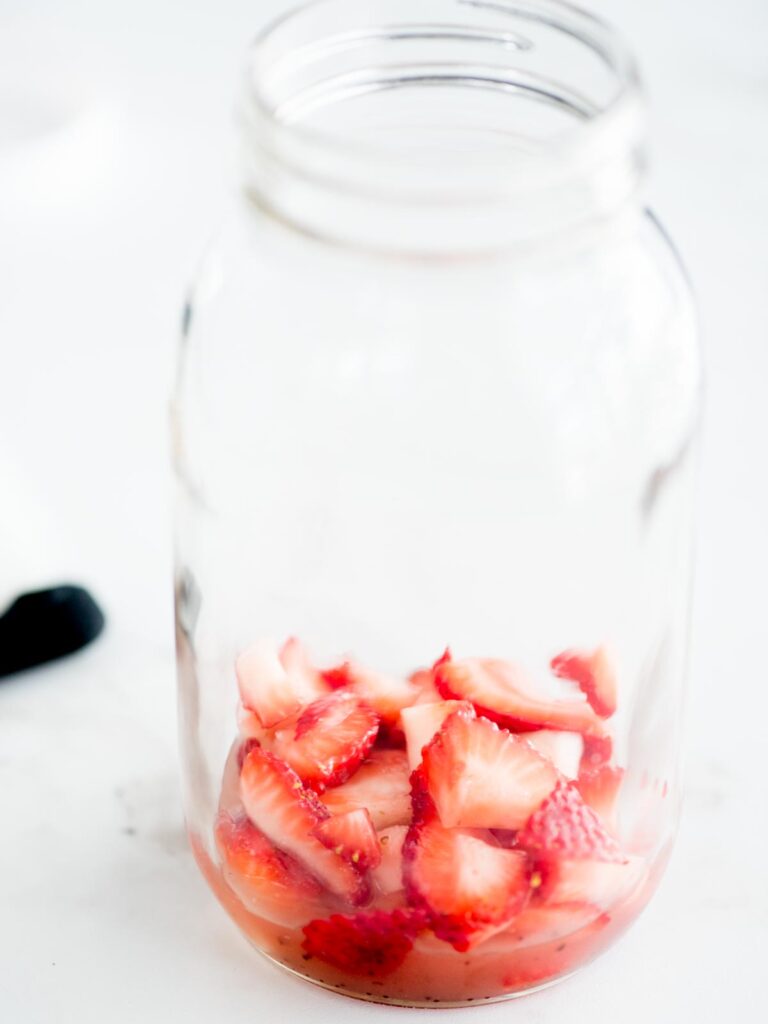 strawberries and raspberry vinaigrette in a mason jar