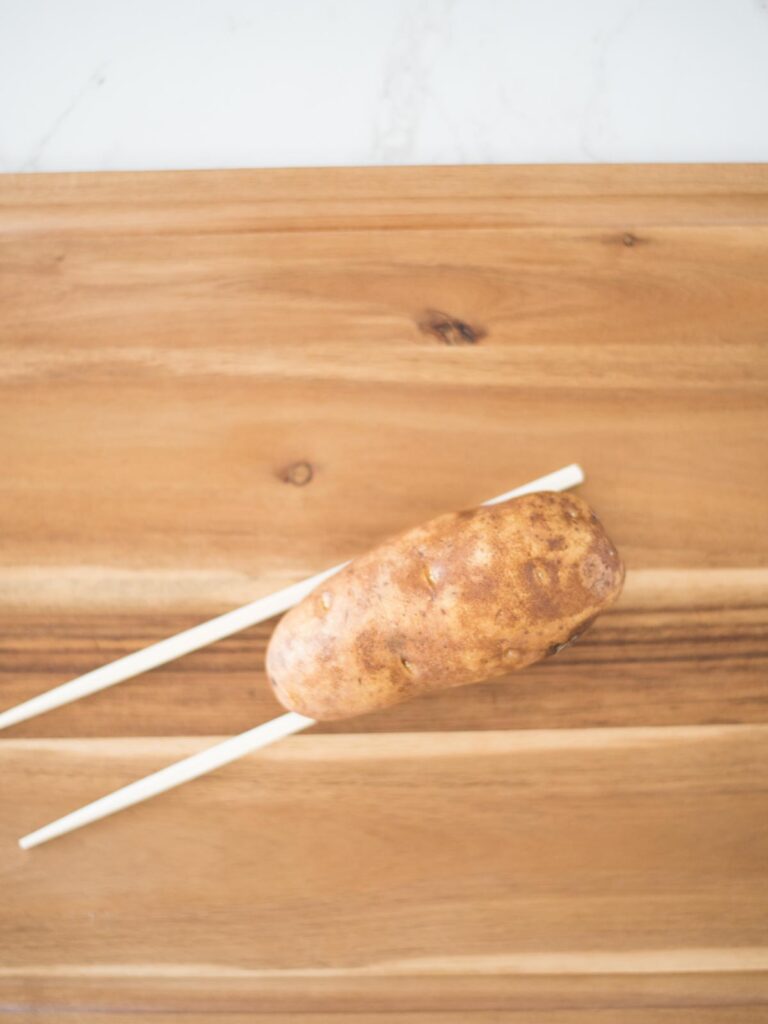 russet potato on chopsticks