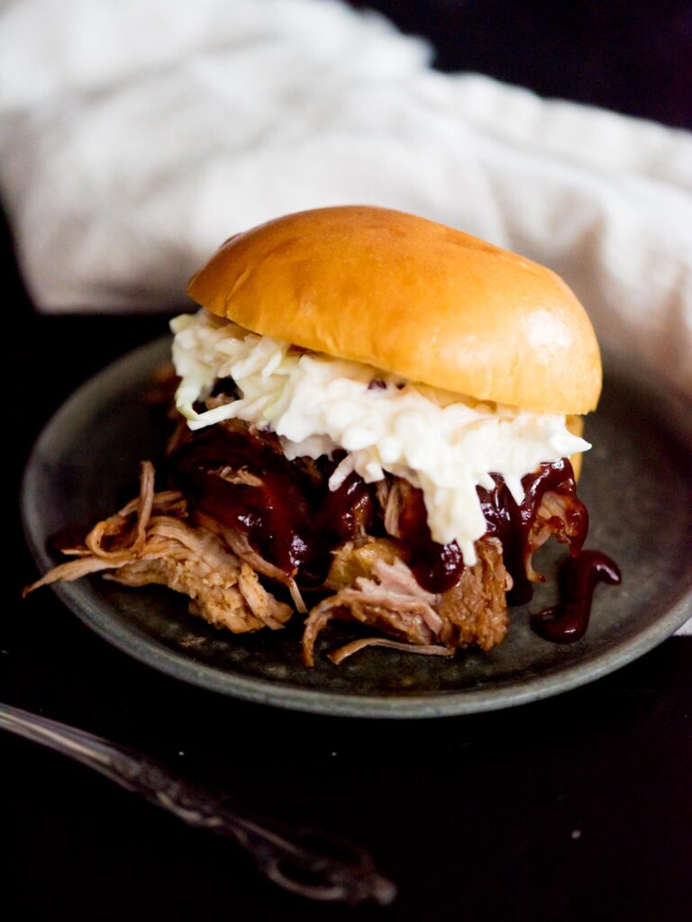 instant pot sweet pulled pork with bbq sauce and coleslaw in a brioche bun