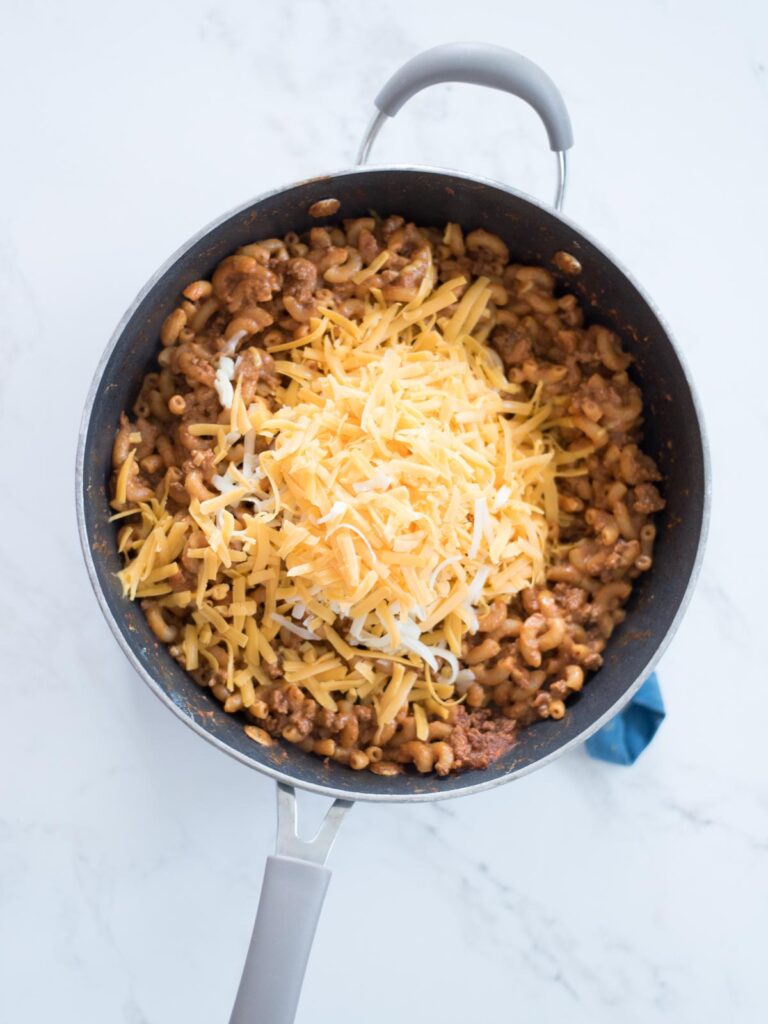 one pot cheesy taco pasta in a skillet topped with cheese